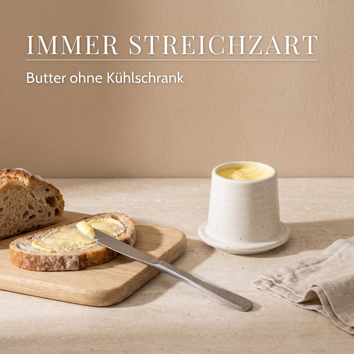 Streichzarte Butter auf Brot neben der Butterglocke