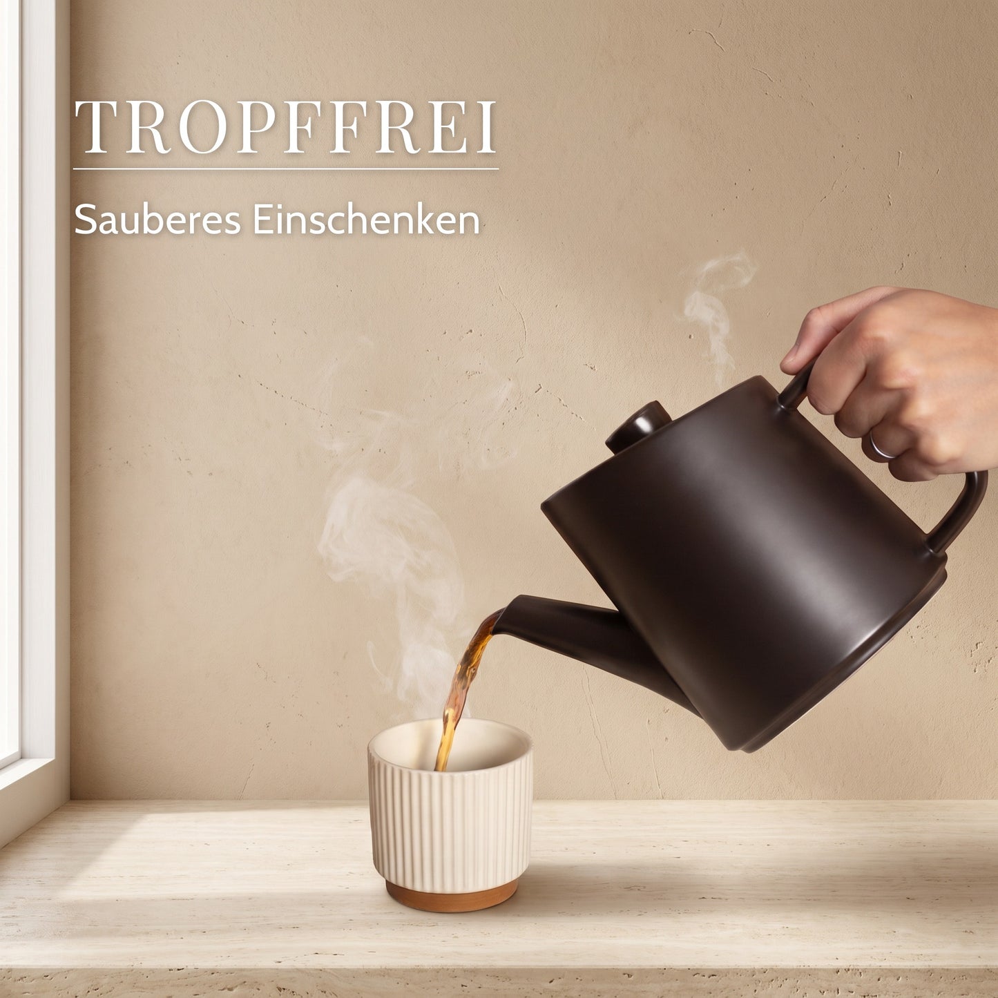 Tee wird aus der Kanne in eine Tasse eingeschenkt