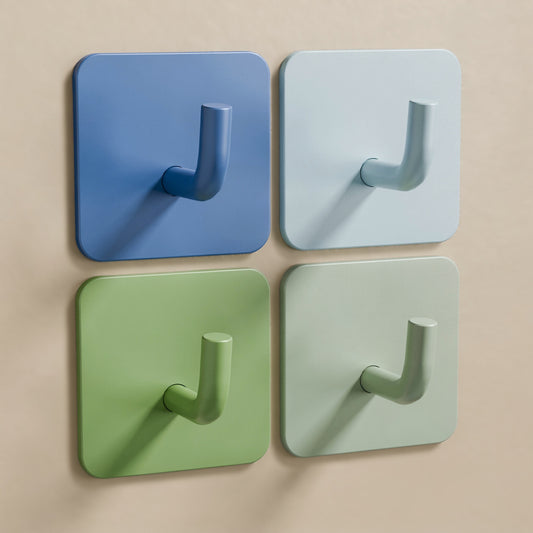 4er-Set Klebehaken Blau-Grün: Blau, Hellblau, Grün und Salbei an einer glatten beigen Wand
