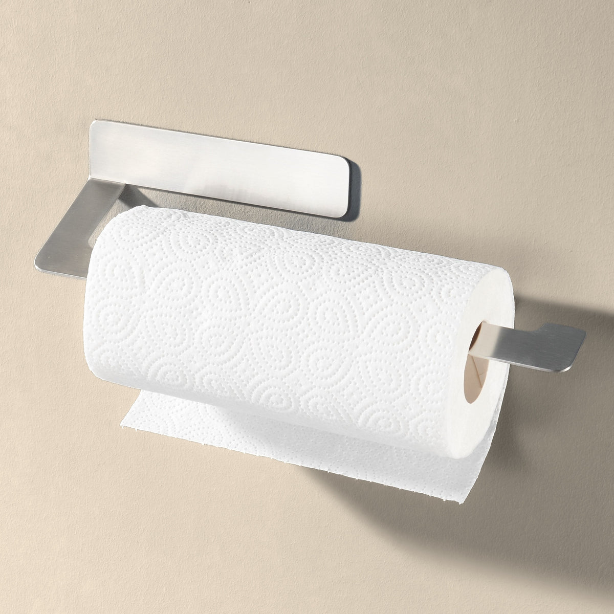 Küchenrollenhalter aus gebürstetem Edelstahl mit voller Rolle an heller Wand