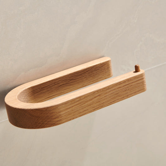 Toilettenpapierhalter aus massiver Eiche an heller Fliese