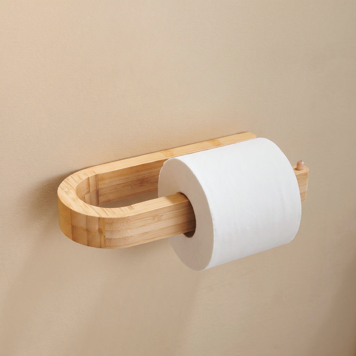 Toilettenpapierhalter aus Bambus mit Rolle an warmer Wand